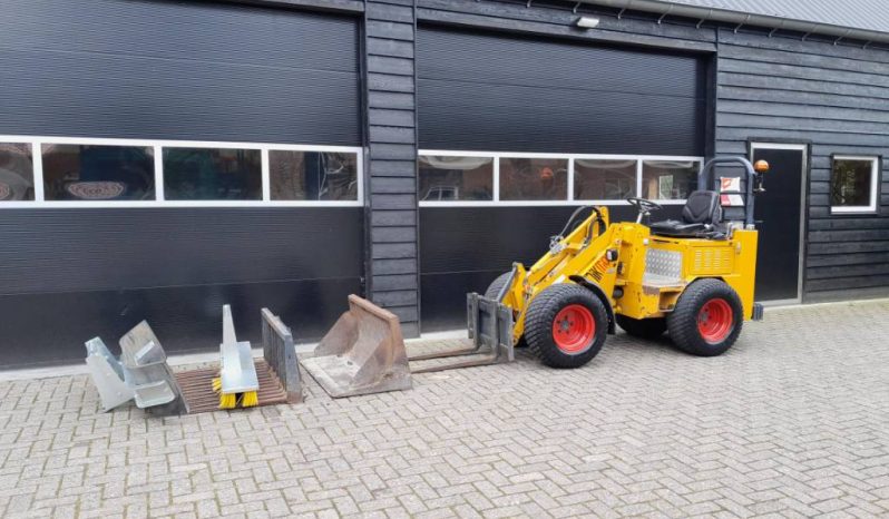 Knikmops 130 minishovel met bak vorken bezem tegelriek vol