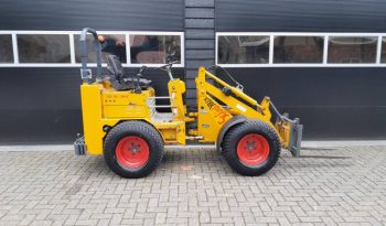 Knikmops 130 minishovel met bak vorken bezem tegelriek vol