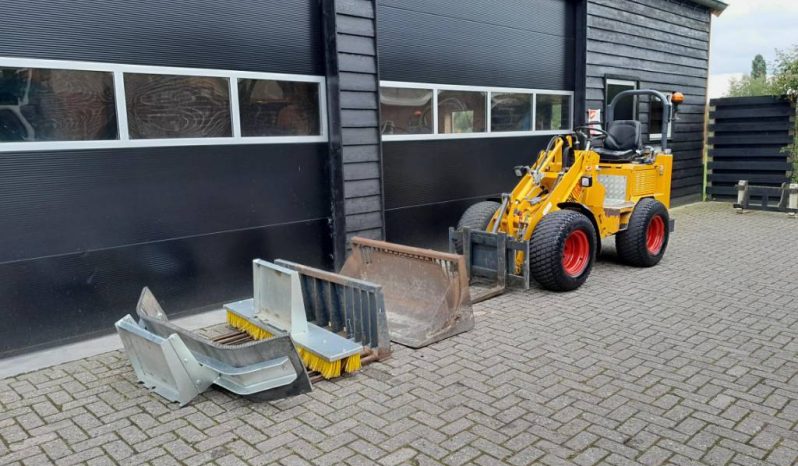 Knikmops 130 minishovel met bak vorken bezem tegelriek vol